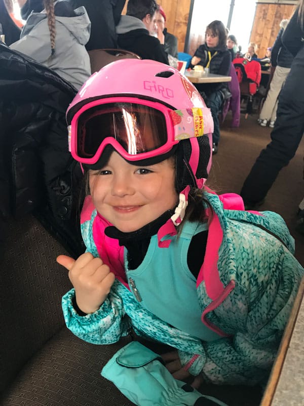 young girl posing wearing ski goggles and helmet